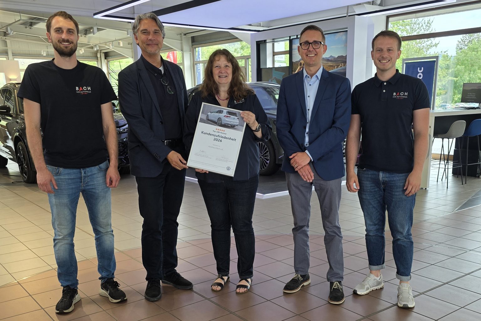 Team des Autohaus Bach mit der Volkswagen Auszeichnung Kundenzufriedenheit 2026 im Showroom
